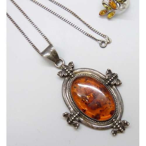 7109 - A large statement silver pendant set with amber on a silver chain, together with a silver and amber ... 