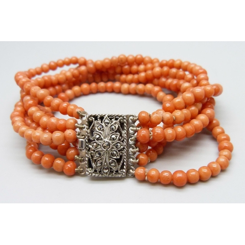 7121 - A five strand coral bracelet with a silver marcasite set clasp, together with a pair of silver gilt ... 