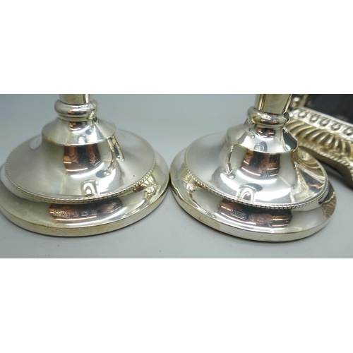 7239 - A pair of silver candlesticks with weighted bases, Birmingham 1969, 18cm, and a silver photograph fr... 