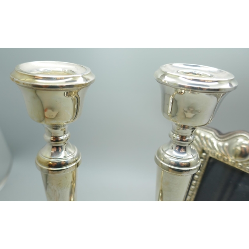 7239 - A pair of silver candlesticks with weighted bases, Birmingham 1969, 18cm, and a silver photograph fr... 