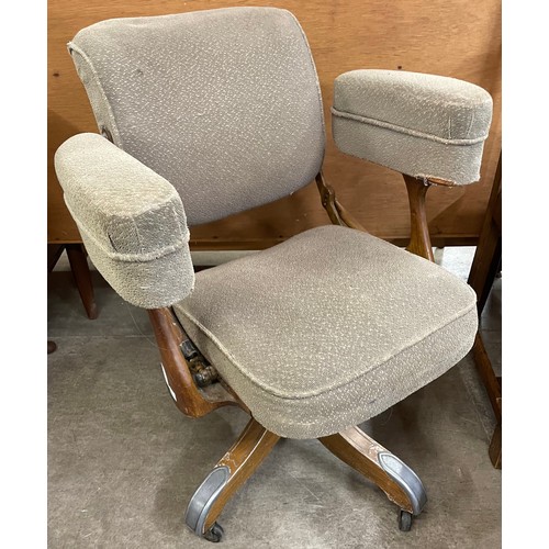 238 - An early 20th Century oak and fabric upholstered revolving office chair