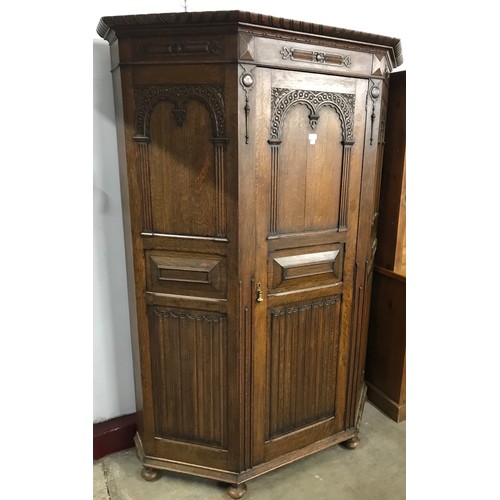 117 - An early 20th Century Jacobean Revival carved oak linenfold hallrobe