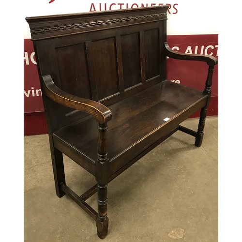 129 - An early 20th Century Jacobean Revival oak settle