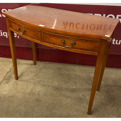 186 - A Regency style yew wood two drawer bow front hall table