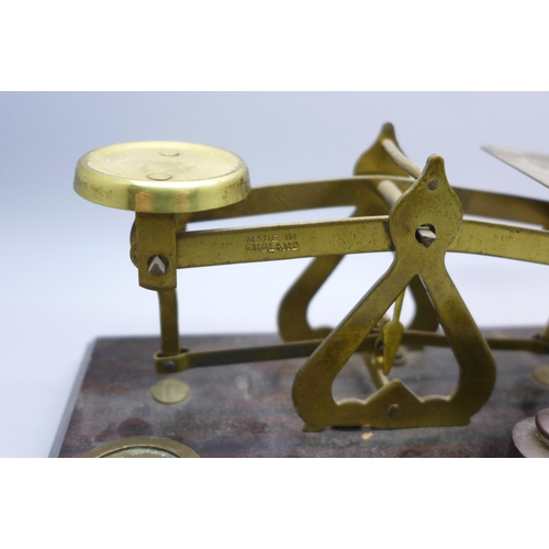 2032 - A set of brass and wooden balance scales marked ‘made in England’ and a collection of weights