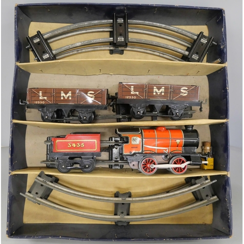 2134 - A clockwork Hornby Train 0 gauge M1 goods set having no.3435 locomotive in red and two LMS wagons. W... 