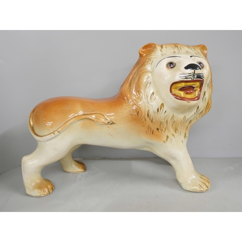 2195 - A Staffordshire model of a lion and a pair of 19th century plaster Staffordshire style spaniel figur... 