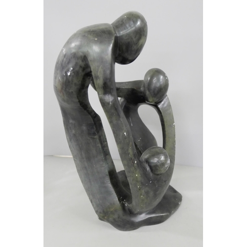 2199 - A soapstone sculptural figure group, three figures embraced in a circle, 32cm