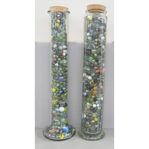 2208 - Two large cylindrical glass jars containing marbles and a tin of marbles, including some latticino