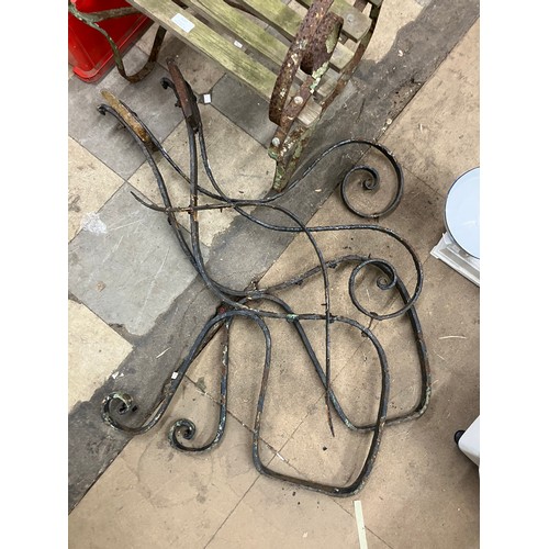 320 - A Victorian wrought iron garden chair and a pair of bench ends