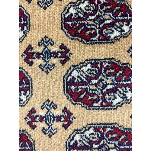 3165 - A Bokhara style gold ground anti-slip runner rug