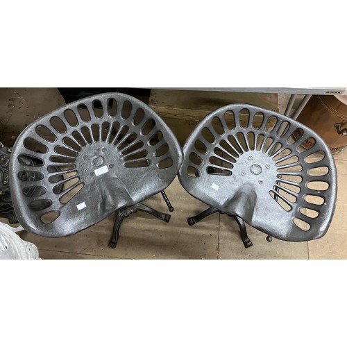 329 - Two cast metal tractor stools