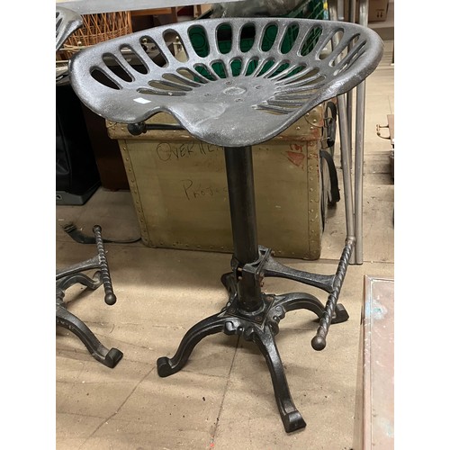 329 - Two cast metal tractor stools