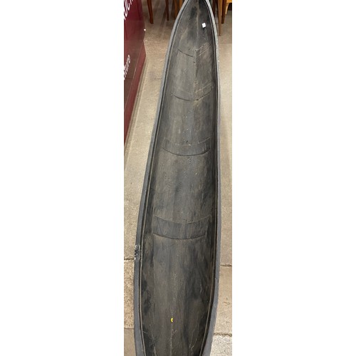 292 - A North American ebonised hardwood model canoe on stand