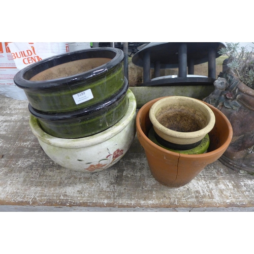 5207 - A bird feeder with feeders, bird table, a Hozelock auto reel and hose and various plant pots