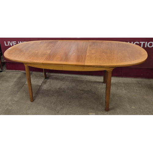 15 - A Nathan teak oval extending dining table and four chairs