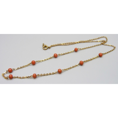 7025 - A 9ct gold necklace with coral beads, stamped 9C, 2.6g, 44cm