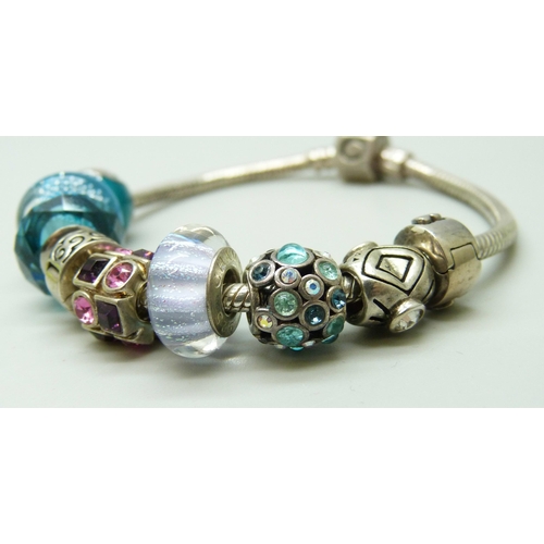 7038 - A silver Chamilia bracelet with nine silver Chamilia charms, a Swarovski charm and an unmarked charm... 