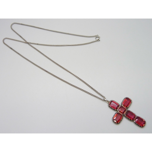 7047 - A vintage Georgian style silver and red paste stone cross pendant, tests as silver, on a long silver... 