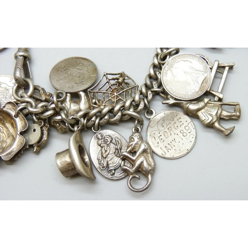 7052 - A silver Albert chain charm bracelet with 27 silver and white metal charms, 73g