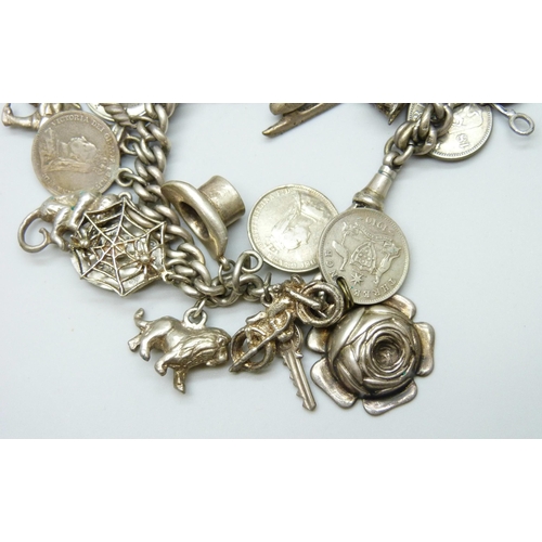 7052 - A silver Albert chain charm bracelet with 27 silver and white metal charms, 73g