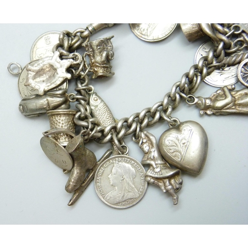 7052 - A silver Albert chain charm bracelet with 27 silver and white metal charms, 73g