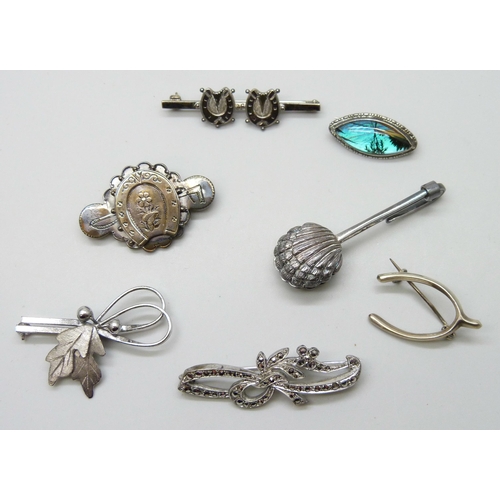 7054 - A collection of Victorian and later silver brooches, together with a silver napkin clip, 33g total