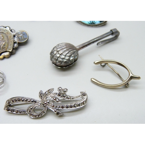 7054 - A collection of Victorian and later silver brooches, together with a silver napkin clip, 33g total