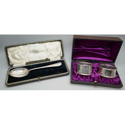 7247 - A silver spoon together with two silver unmatched napkin rings, all cased, 65g