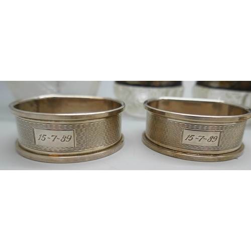 7250 - Two silver napkin rings, 22g, two silver rimmed salts, an atomiser with silver collar, and a beadwor... 