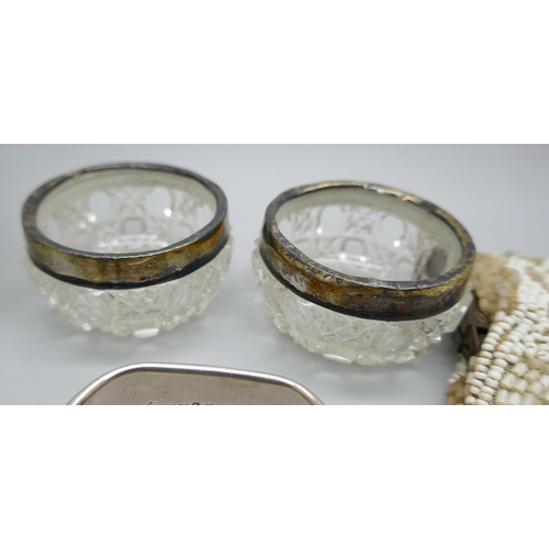 7250 - Two silver napkin rings, 22g, two silver rimmed salts, an atomiser with silver collar, and a beadwor... 