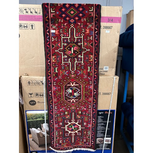 3142 - A full pile Persian red ground runner rug, with medallion design