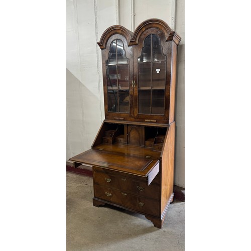 151 - A Queen Anne style walnut dome topped bureau bookcase