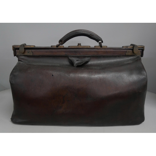 2147 - A vintage brown leather Gladstone bag with handle and brass fixtures.