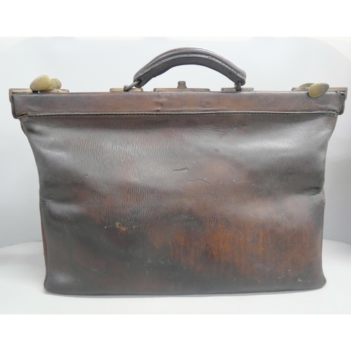 2147 - A vintage brown leather Gladstone bag with handle and brass fixtures.