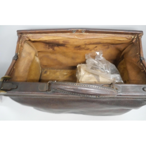 2147 - A vintage brown leather Gladstone bag with handle and brass fixtures.