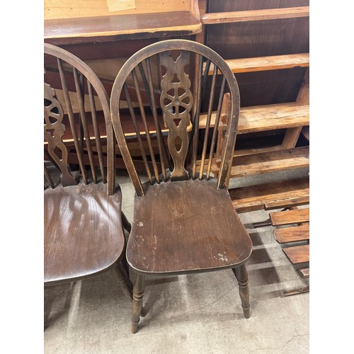 283 - A set of four early 20th Century elm and beech wheelback kitchen chairs