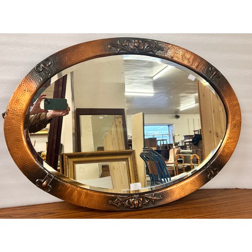 369 - An Arts and Crafts copper framed oval mirror