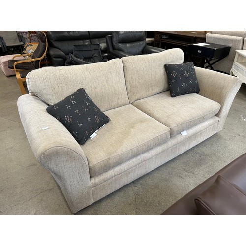 3295 - An oatmeal upholstered three seater sofa (marked cushions)