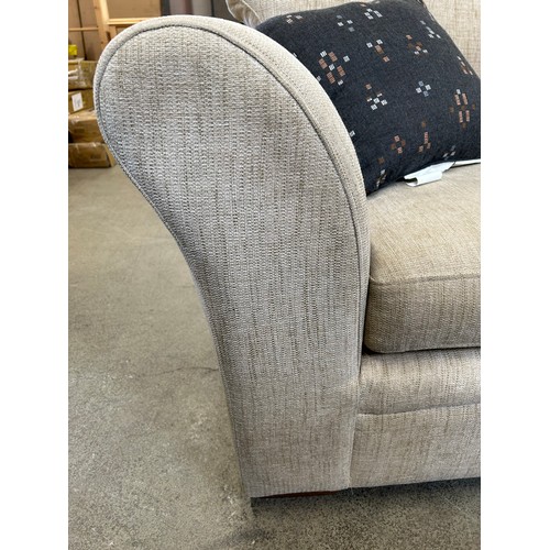 3295 - An oatmeal upholstered three seater sofa (marked cushions)