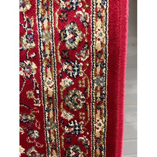 3081 - A red ground full pile cashmere runner with an all over floral design