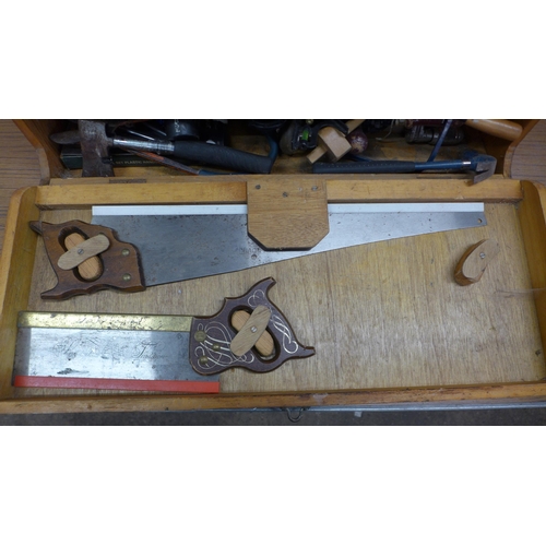 5055 - A wooden box of tools including saws, brace drill, sharpening stone, hammer, etc.