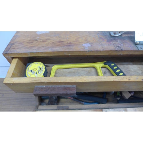 5055 - A wooden box of tools including saws, brace drill, sharpening stone, hammer, etc.