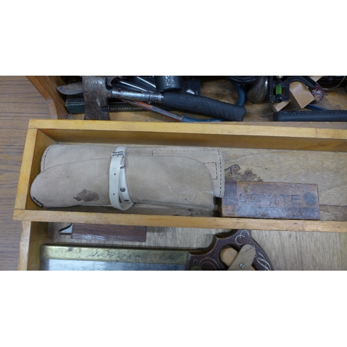 5055 - A wooden box of tools including saws, brace drill, sharpening stone, hammer, etc.