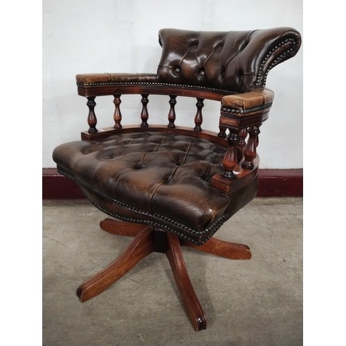 141 - A mahogany and chestnut brown leather revolving Captains desk chair