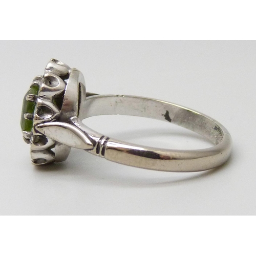 7050 - A white metal, peridot and diamond cluster ring, stamped 18ct, 4.9g, O