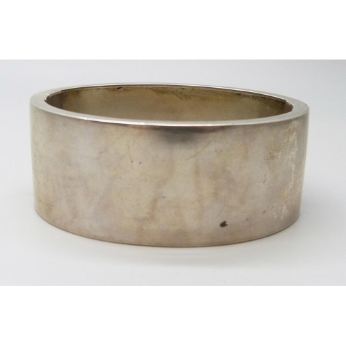 7102 - A Victorian white metal bangle with applied gold decoration, 36g, 4.7 x 5.7cm, 2.5cm wide