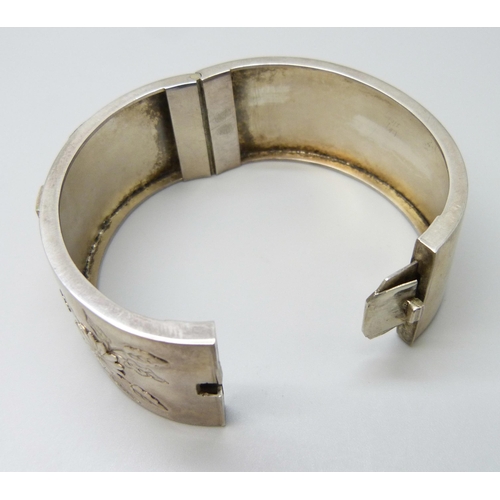 7102 - A Victorian white metal bangle with applied gold decoration, 36g, 4.7 x 5.7cm, 2.5cm wide