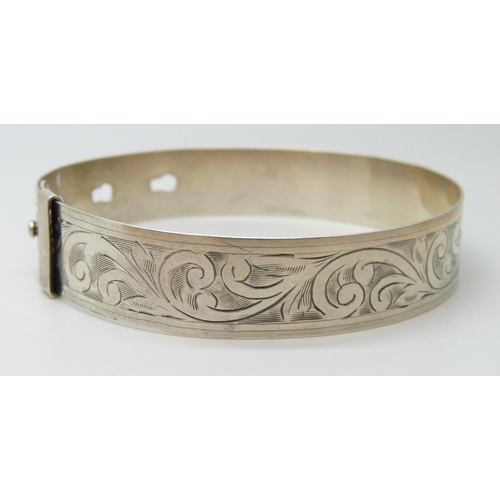 7105 - An engraved silver bangle, adjustable, 16g, 6.3cm, 1.3cm wide