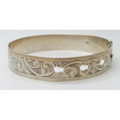 7105 - An engraved silver bangle, adjustable, 16g, 6.3cm, 1.3cm wide